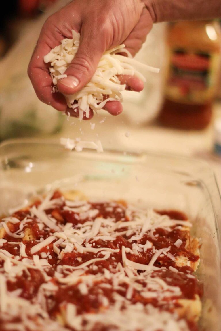 cheese being spread onto pizza