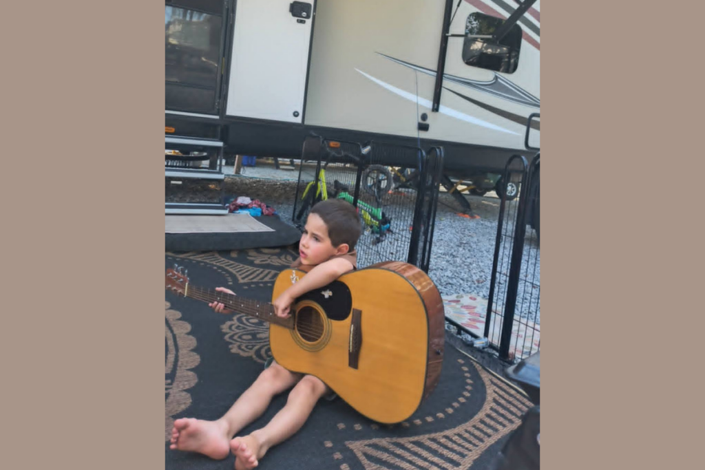 101 RV Homeschool: The Best Guide to Homeschooling While Full-Time RVing 11 Child exploring music education by learning guitar as part of RV homeschooling curriculum for creative learning and family homes