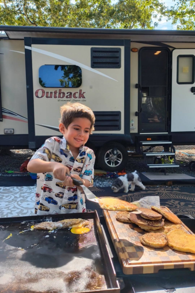 RV Activities for Kids: 50+ Amazing Ideas for Fun Family RV Living 11 Child making pancakes on a Blackstone grill as one of the best RV kid friendly activities for families while camping