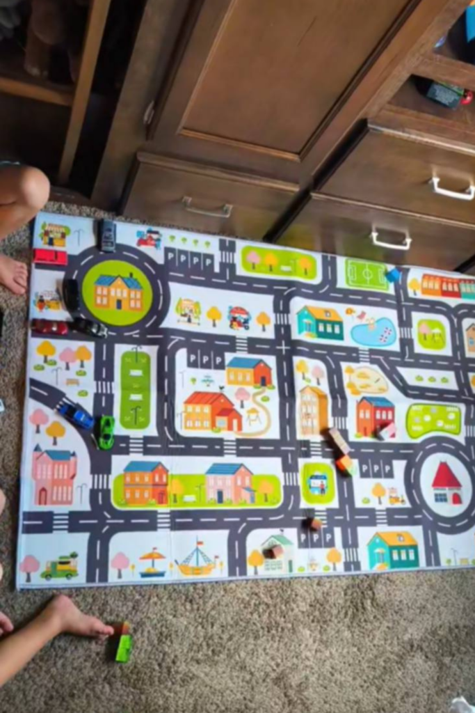 RV Activities for Kids: 50+ Amazing Ideas for Fun Family RV Living 7 Child playing with a car rug as one of the easiest indoor RV activities for kids during rainy weather