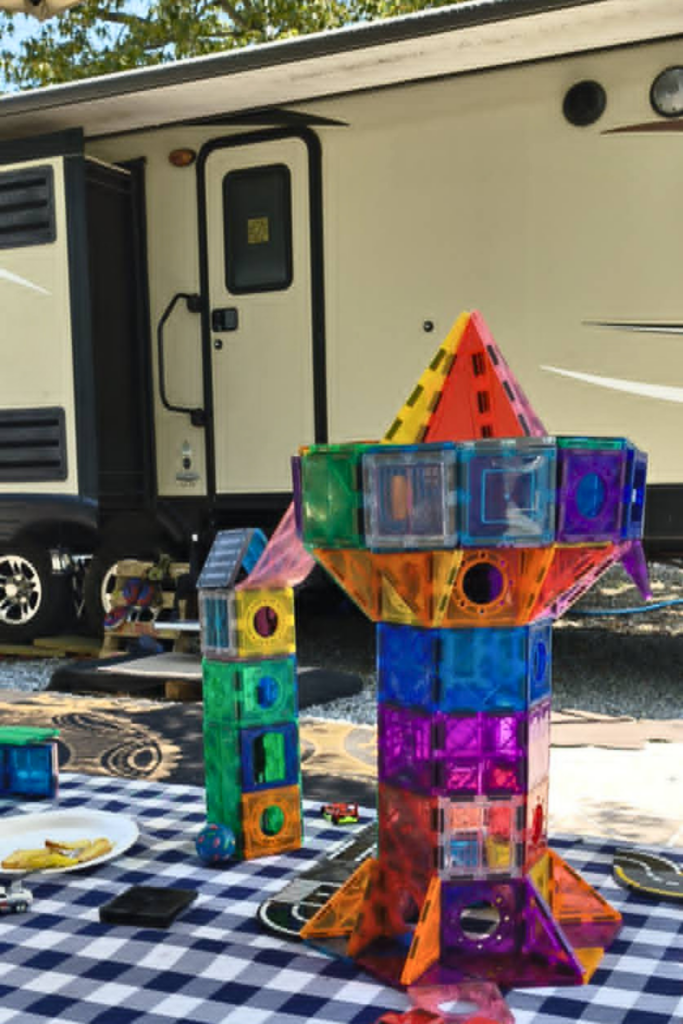 RV Activities for Kids: 50+ Amazing Ideas for Fun Family RV Living 3 Children creating a Paw Patrol pretend play scene with Magna-Tiles as creative indoor RV activities for kids