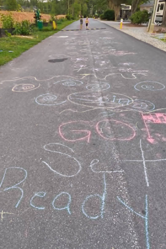 RV Activities for Kids: 50+ Amazing Ideas for Fun Family RV Living 10 Creative chalk art hopscotch with fun challenges as one of the best camping activities for kids at an RV campground.