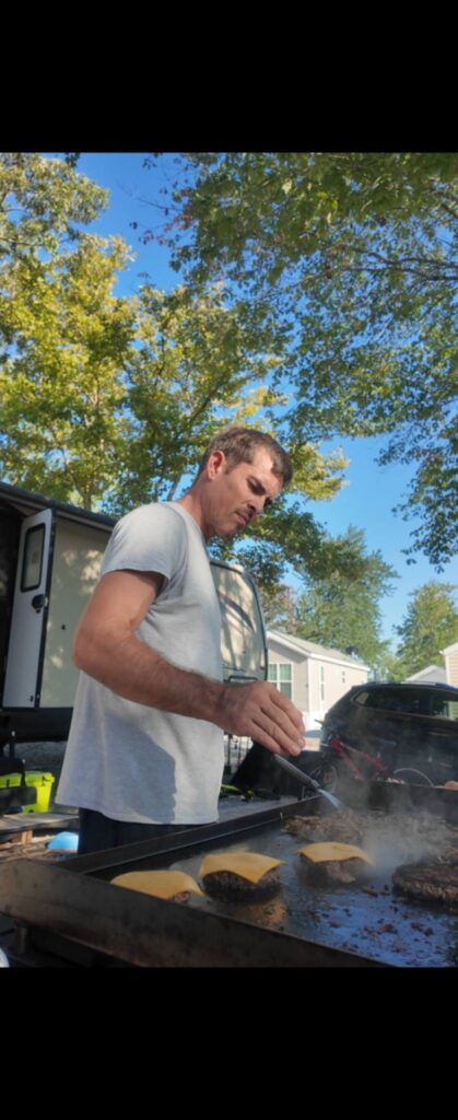 47 Amazon RV Must Haves We Actually Use in Our RV 4 Husband cooking breakfast on a Blackstone griddle outside our RV